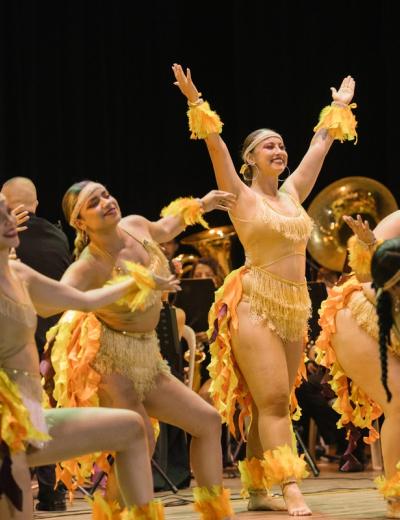Bailarinas con vestuario de fuego frente a la banda
