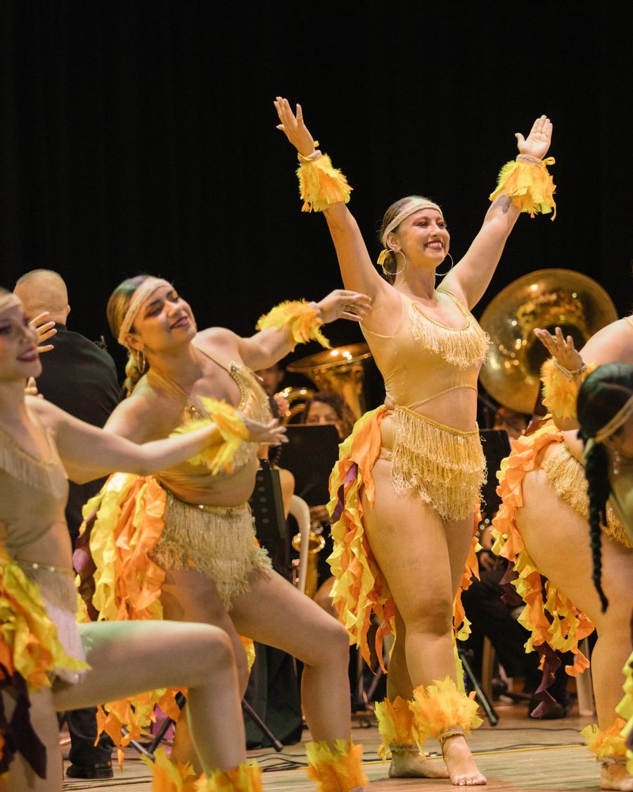 Bailarinas con vestuario de fuego frente a la banda