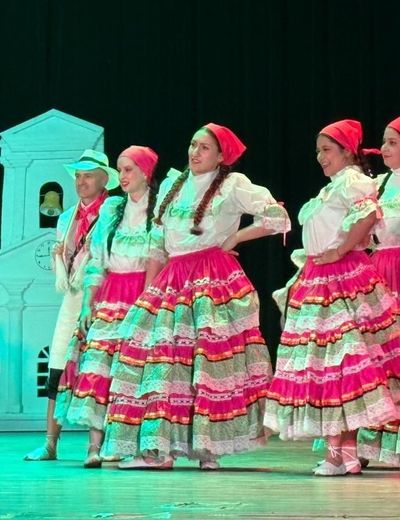 Bailarinas con falda de franjas de colores y pañoleta rosada