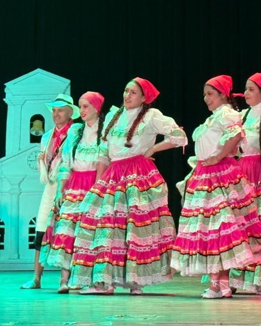 Bailarinas con falda de franjas de colores y pañoleta rosada