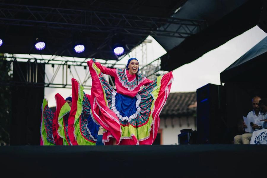 Bailarina con pollera de colores abierta en tarima
