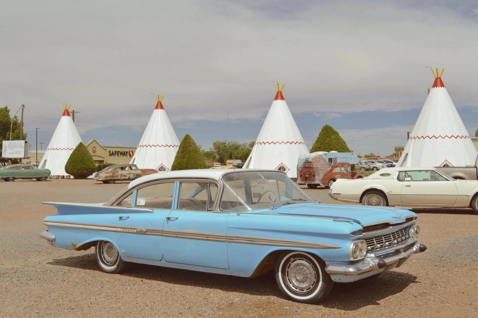 Classic cars parked in front of the cone-shaped rooms at Wigwam Motel on Route 66