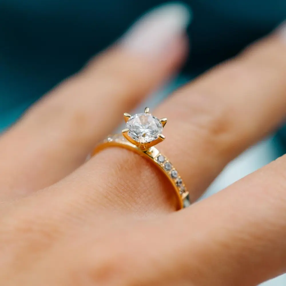 Lab diamantring med en diamant i senter og flere små på siden i gult gull