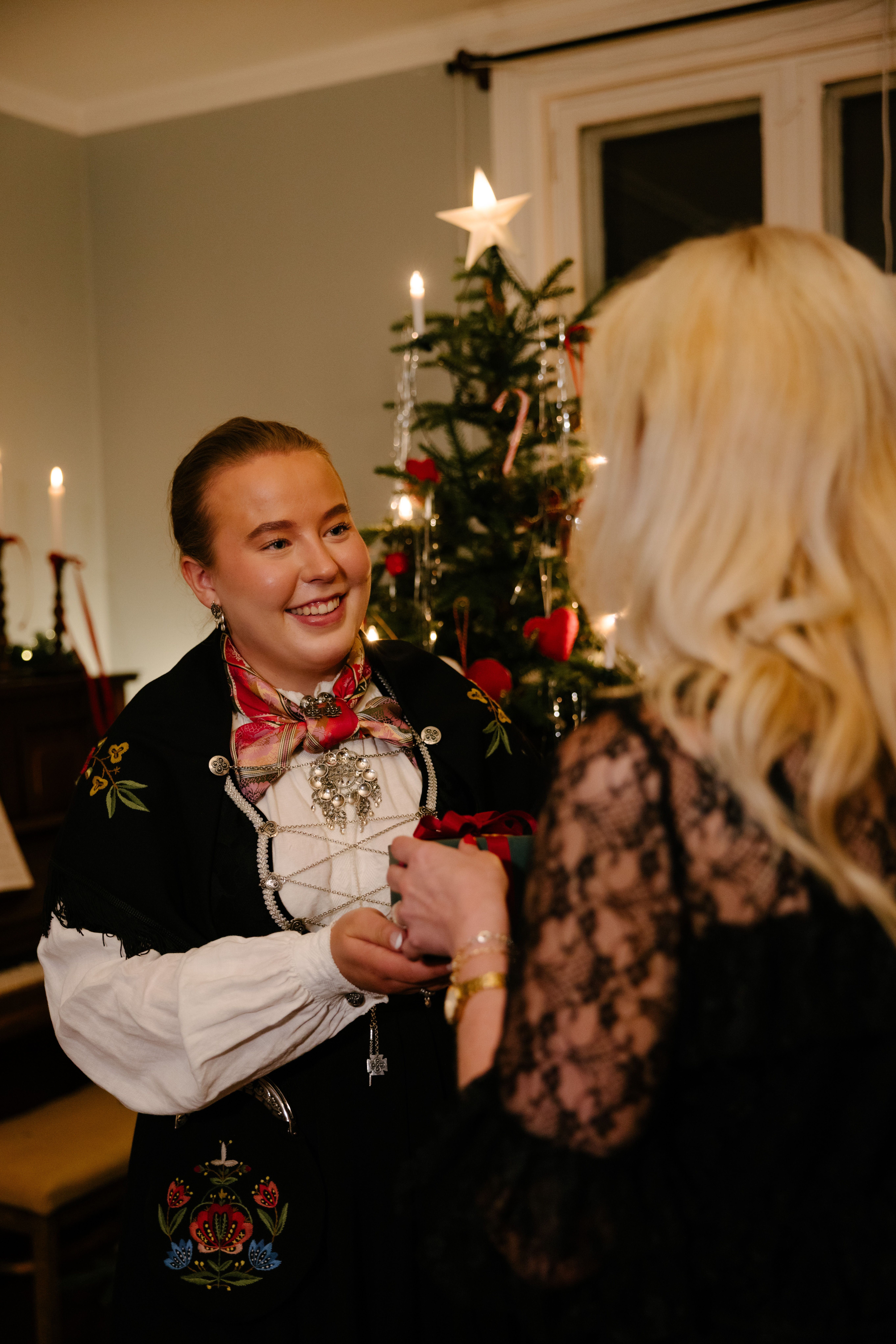Kvinne som smiler og mottar julegave fra Gullfunn
