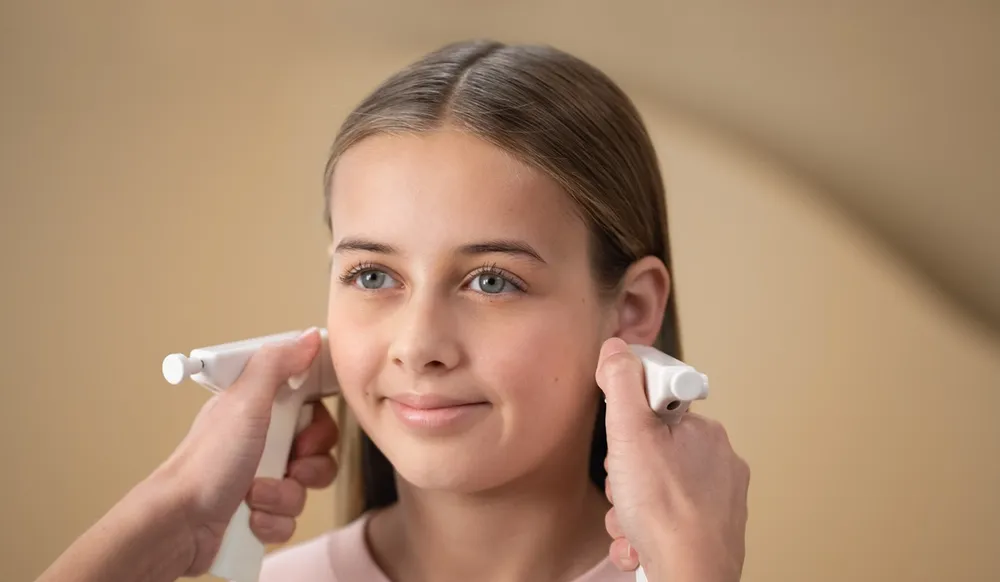 En jente som får nye hull i ørene med medisinsk hulltagning