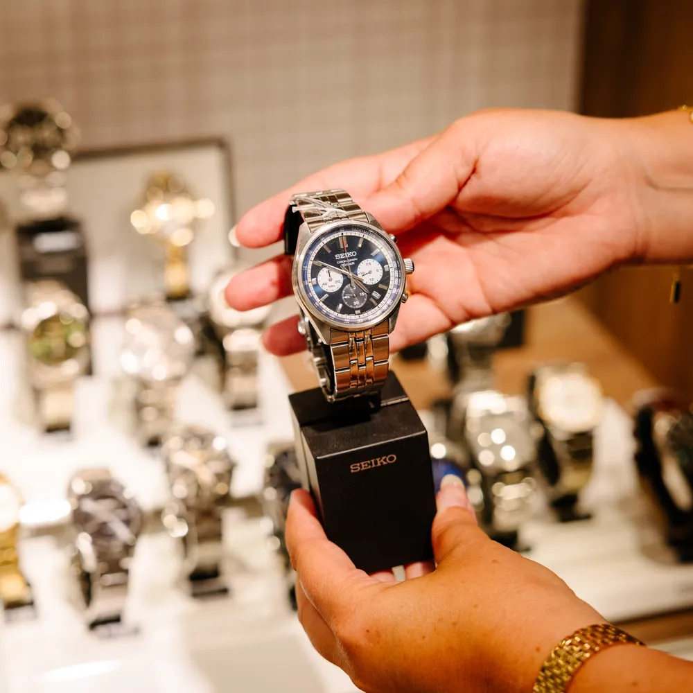 Butikkansatt i Gullfunn viser frem klokke fra Seiko