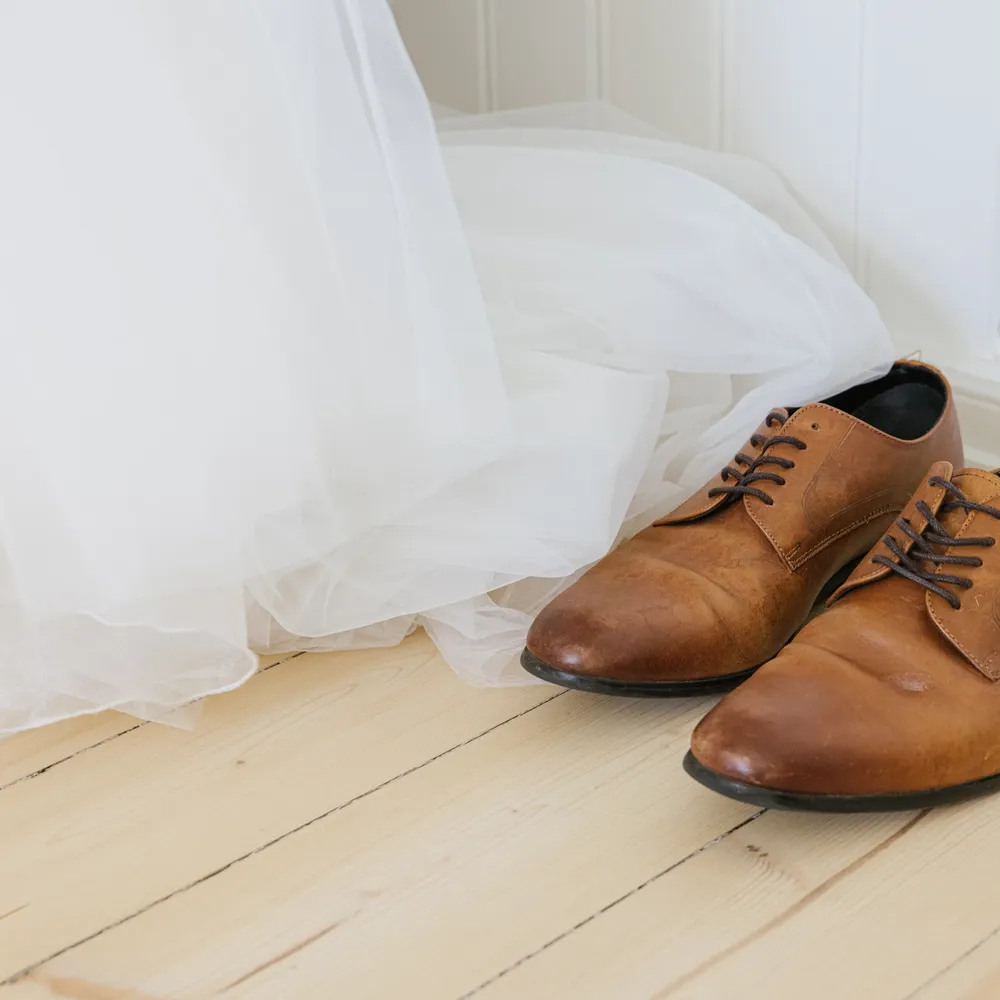 Brudgommens sko sammen med en brudekjole