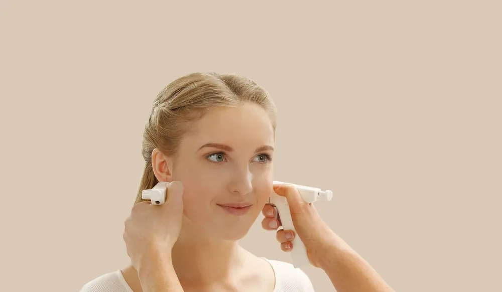 Jente som får hull i ørene med medisinsk hulltagning