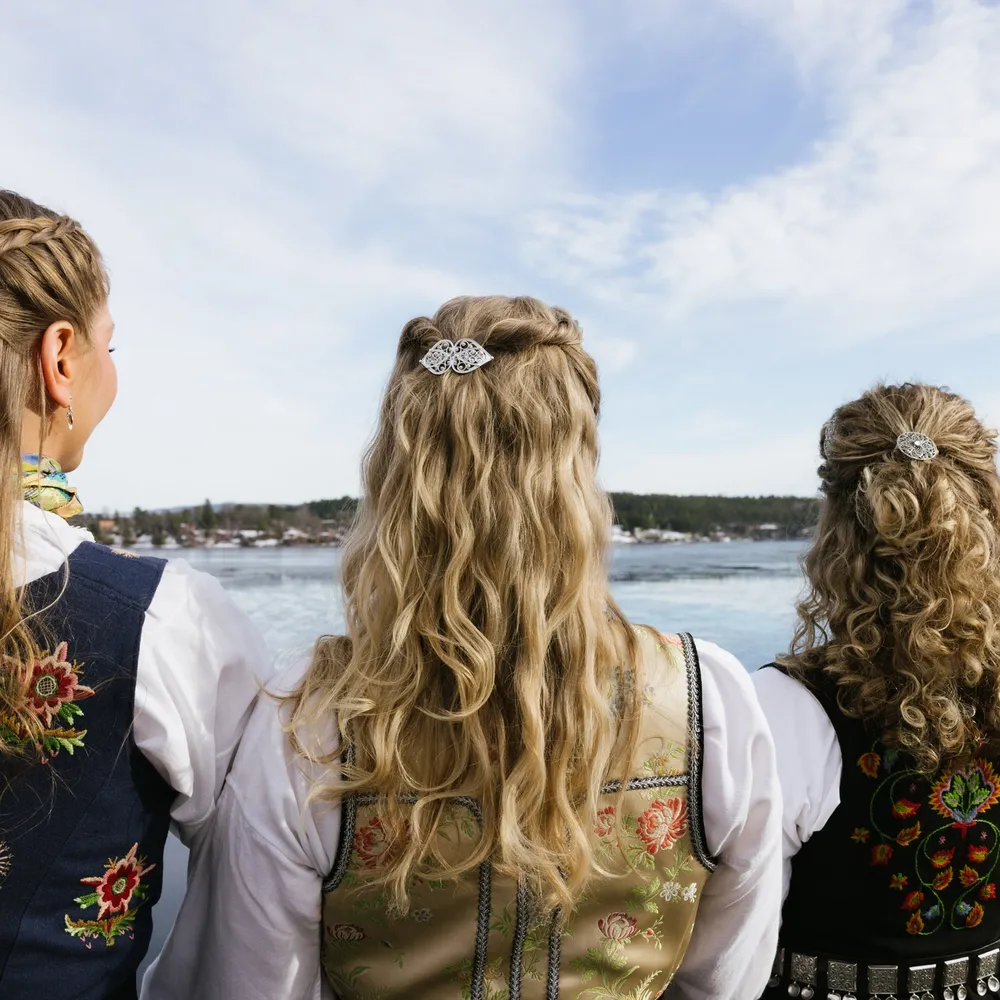 Fire kvinner med bunadspenner i håret