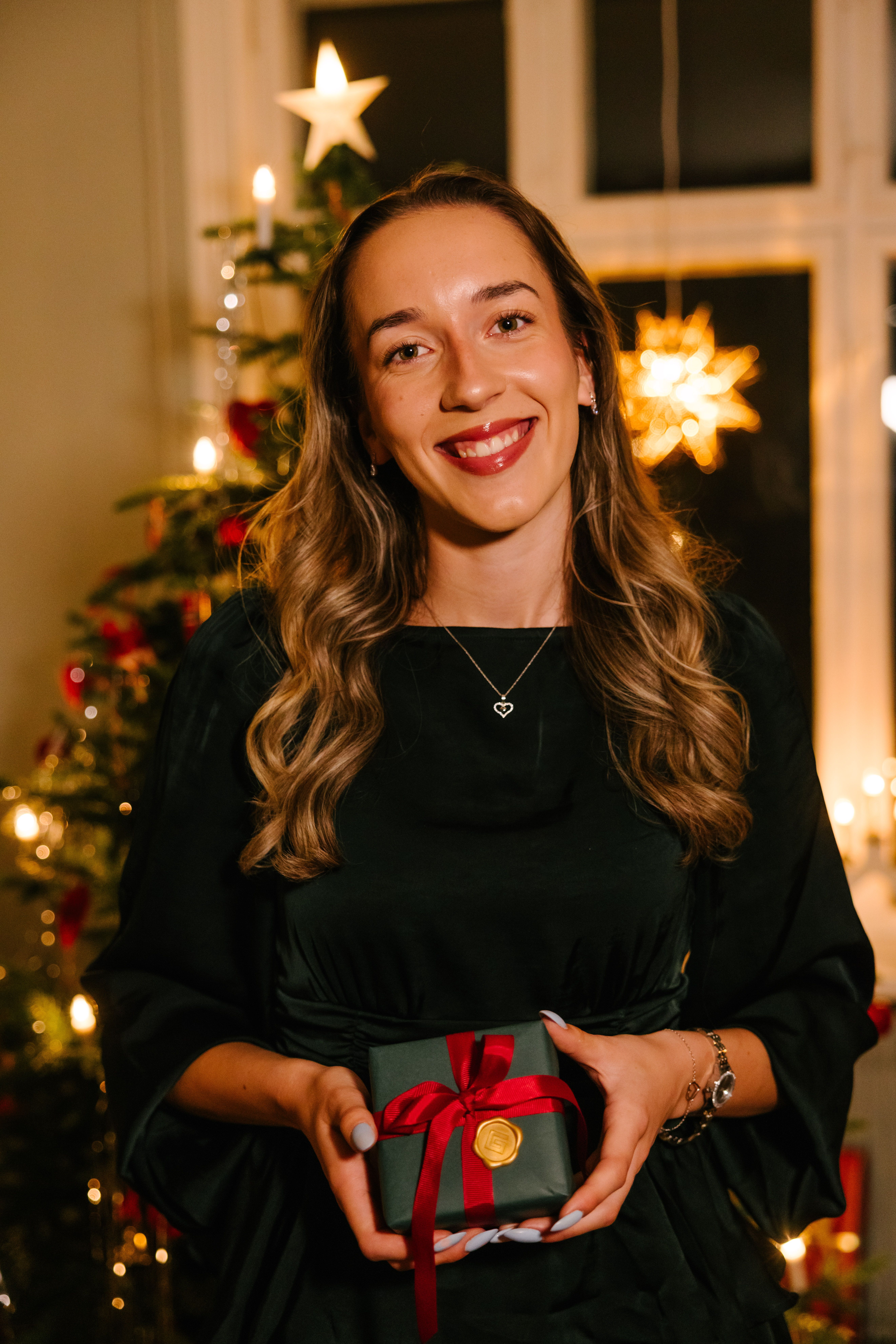 Kvinne som smiler og holder en julegave