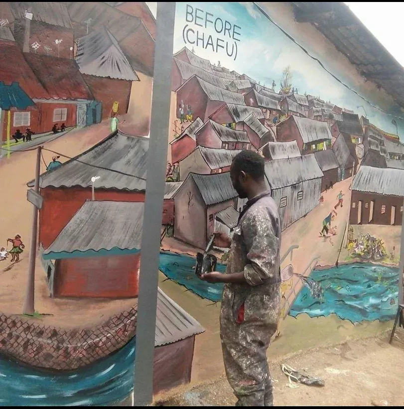 A man painting a mutal of a village