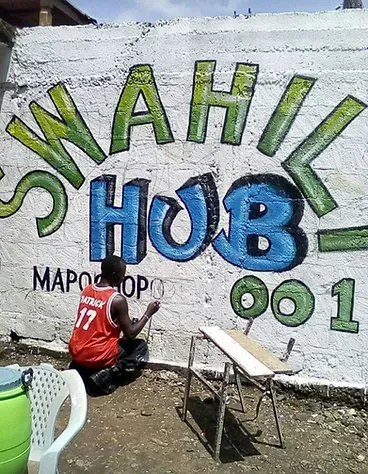 man painting a graffiti mural