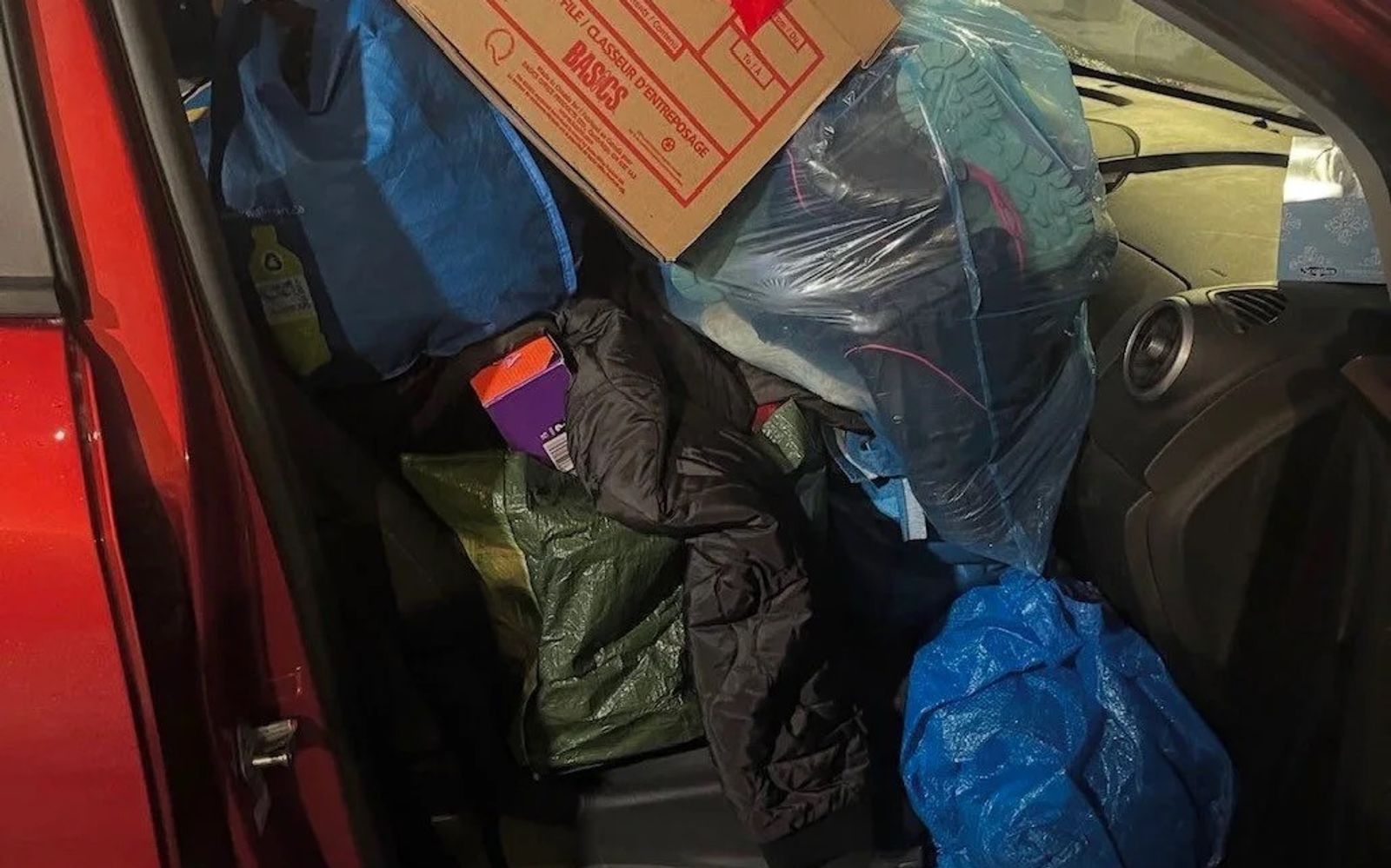 Bags of winter clothing and household goods packed into a car for MC Thrift.