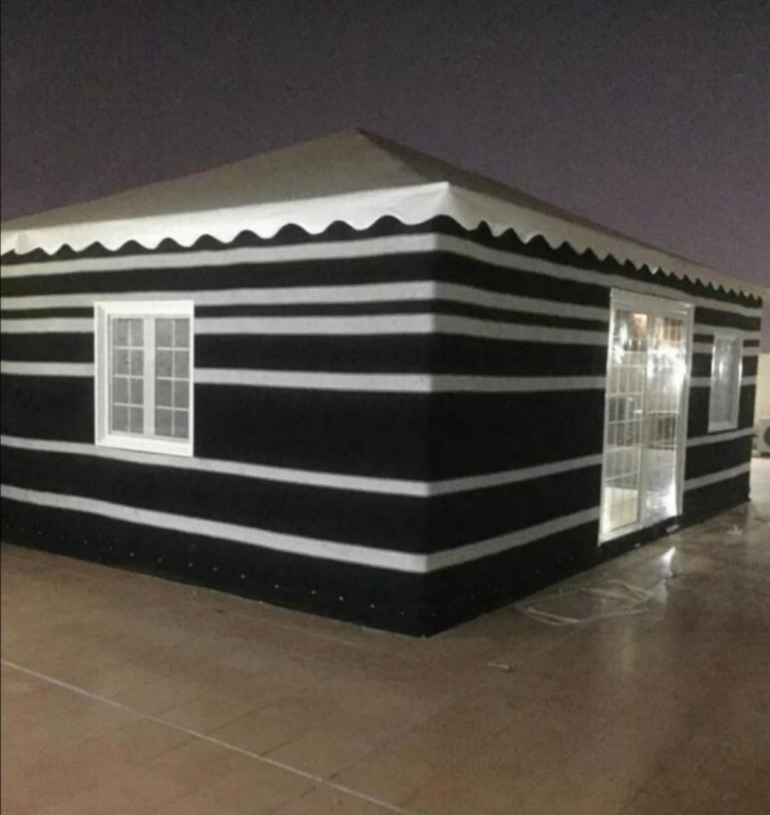 منظر ليلي لبيت شعر ملكي فخم مع إضاءات خارجية وداخلية في مكة