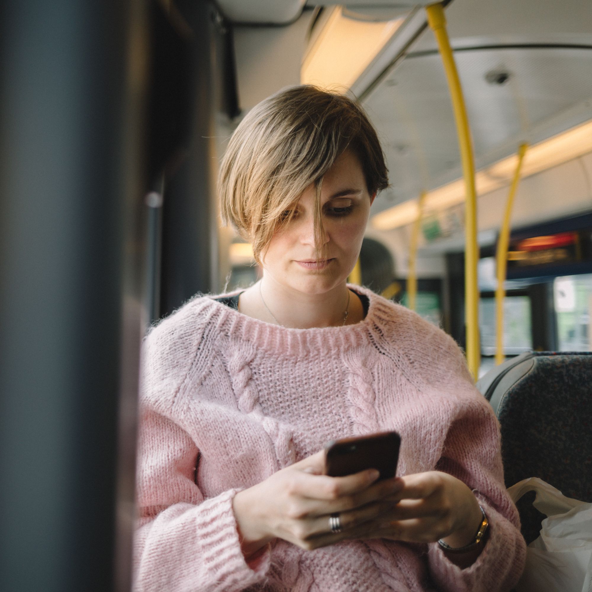 Eksempelbilde: En kvinne som bruker mobil på bussen.