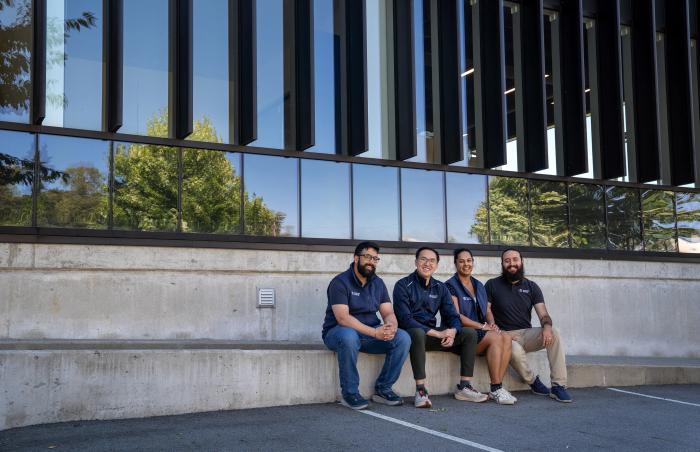 Gurmesh Sidhu, Edward Chiang, Sumreen Rattan and Gabriel Soares sit outside Moment Energy’s newest facility in Surrey, B.C. on Tuesday, June 16, 2026. The four co-founded the company in 2019 in a home garage, aiming to repurpose batteries into clean energy. Former engineering students at Simon Fraser University, the four co-founders first venture together was a meditation company. The new Surrey-based facility is expected to open by the end of June and claims to be the world’s largest in battery repurposing.