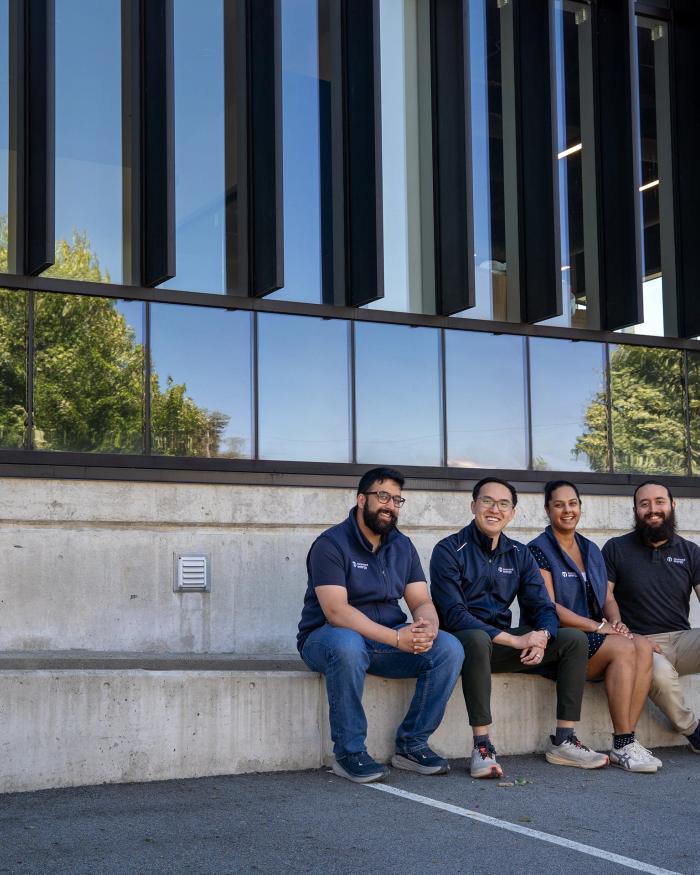 Gurmesh Sidhu, Edward Chiang, Sumreen Rattan and Gabriel Soares sit outside Moment Energy’s newest facility in Surrey, B.C. on Tuesday, June 16, 2026. The four co-founded the company in 2019 in a home garage, aiming to repurpose batteries into clean energy. Former engineering students at Simon Fraser University, the four co-founders first venture together was a meditation company. The new Surrey-based facility is expected to open by the end of June and claims to be the world’s largest in battery repurposing.