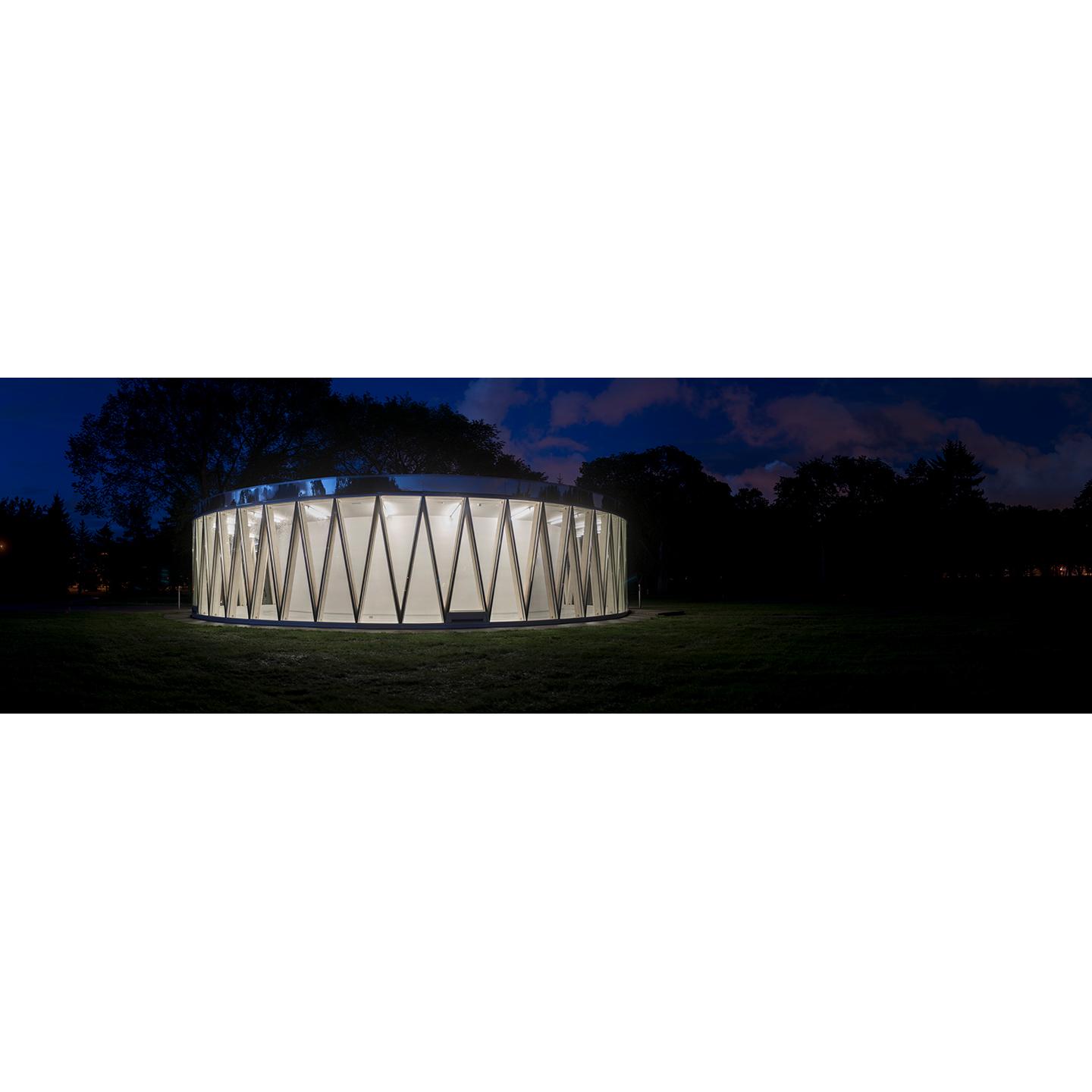 The pavilion by night. The interior structure is made of timber, concrete and glass.