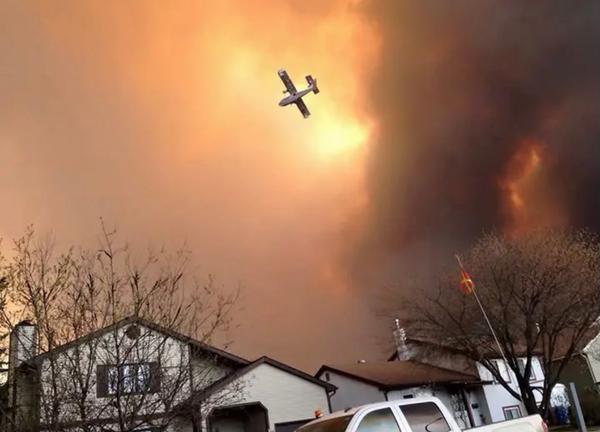 A plane flies through wildfire smoke above Fort McMurray, Alberta, in 2016.