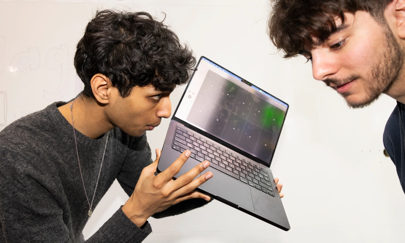 Krish Shah plays his laptop trombone for Symposium attendee Levent Eren.