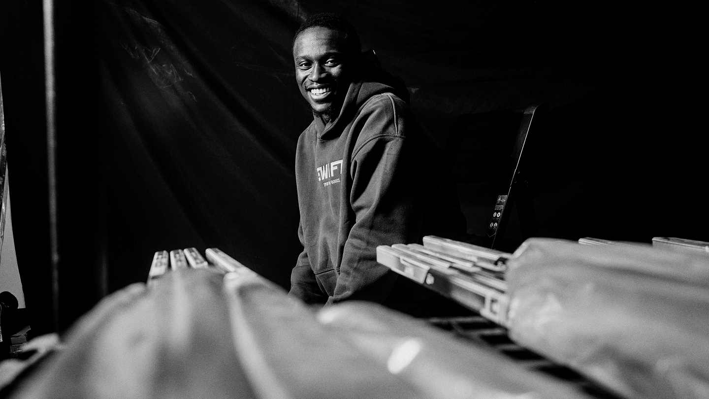 Zechary posing in front of out of focus hockey sticks