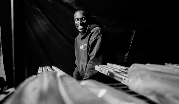 Zechary posing in front of out of focus hockey sticks