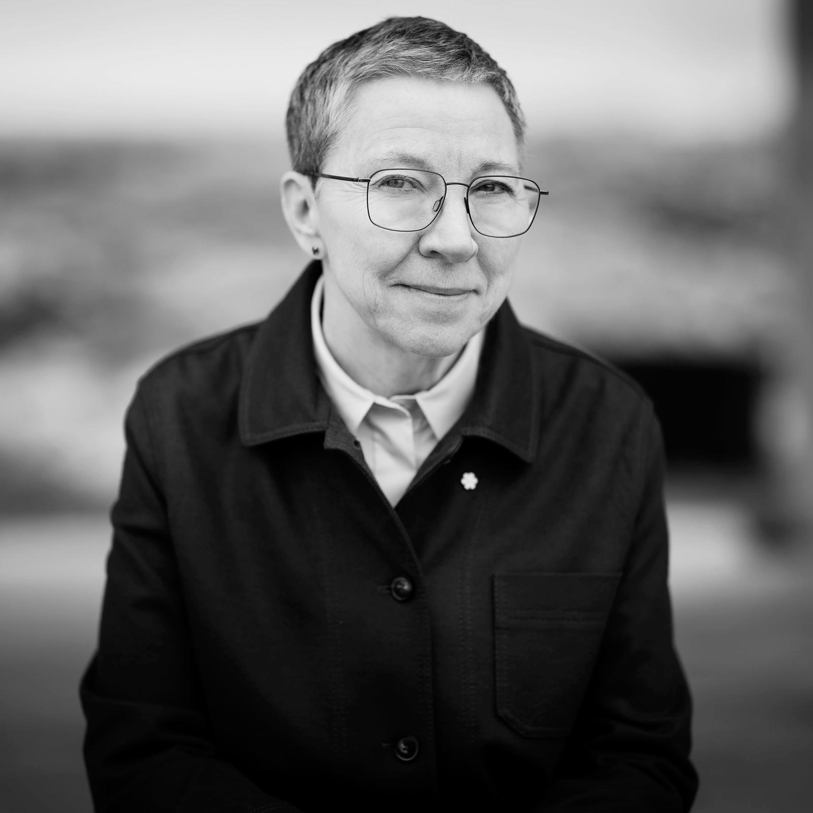 A portrait of Zita Cobb, depicted at the Fogo Island Inn on the staircase overlooking a set of benches and a set of antlers