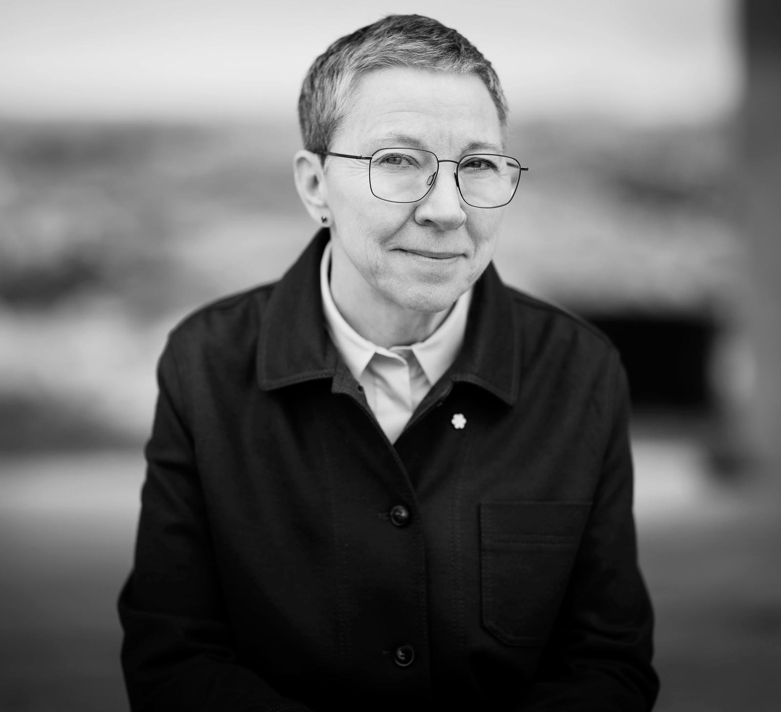 A portrait of Zita Cobb, depicted at the Fogo Island Inn on the staircase overlooking a set of benches and a set of antlers