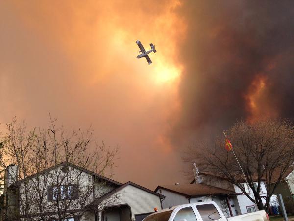 A plane flies through wildfire smoke above Fort McMurray, Alberta, in 2016.