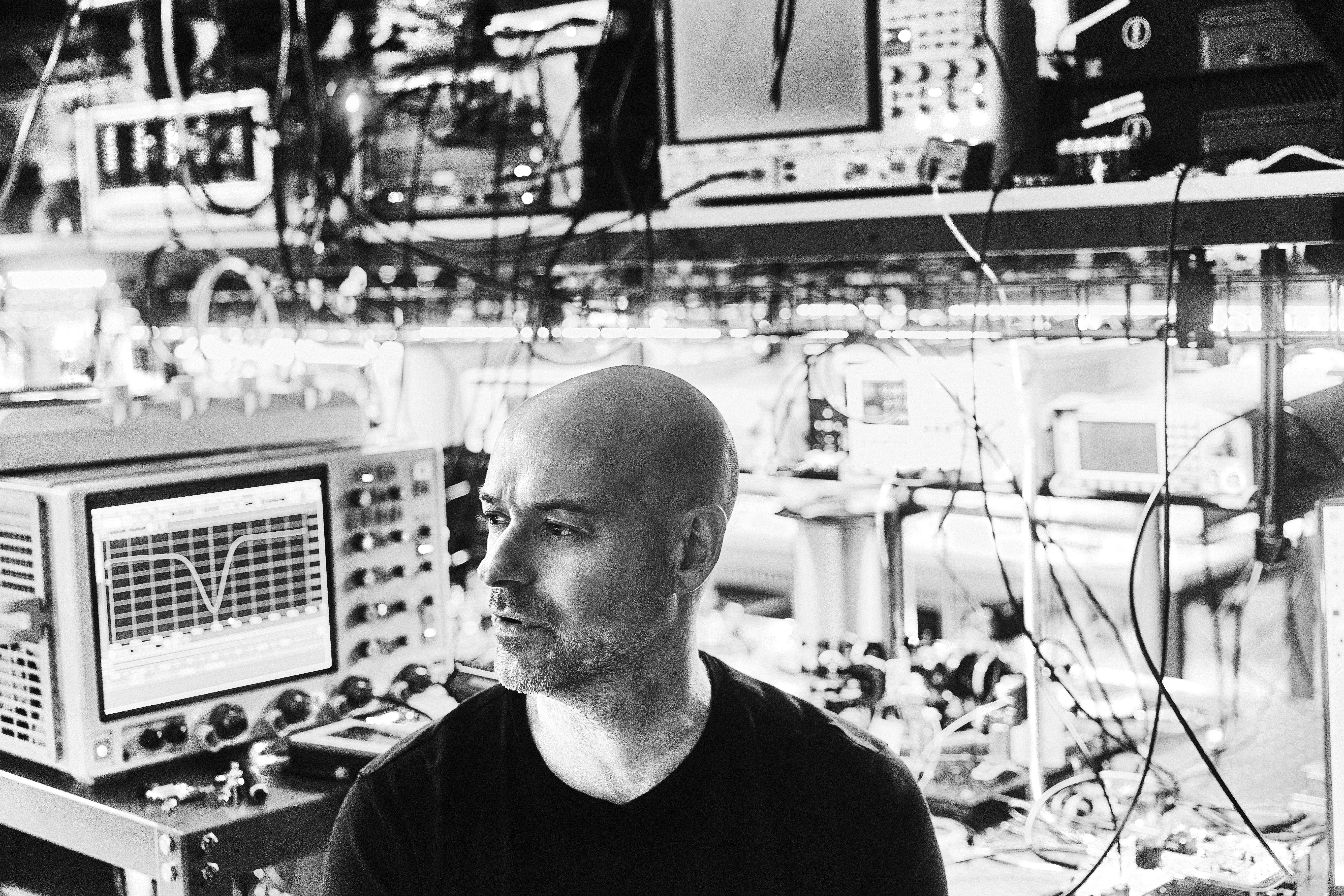 Side profile view of Christian Weedbrook, CEO of Xanadu, with a background of computer tech