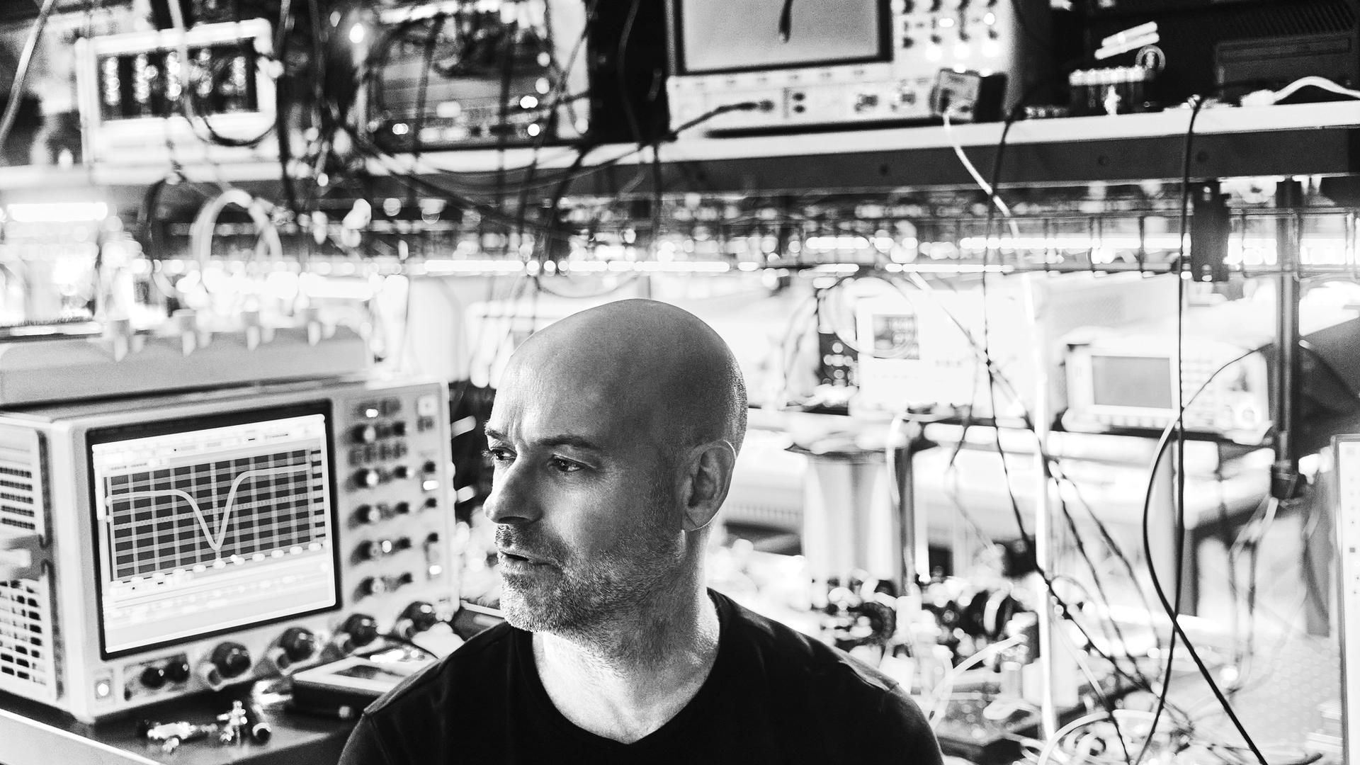 Side profile view of Christian Weedbrook, CEO of Xanadu, with a background of computer tech