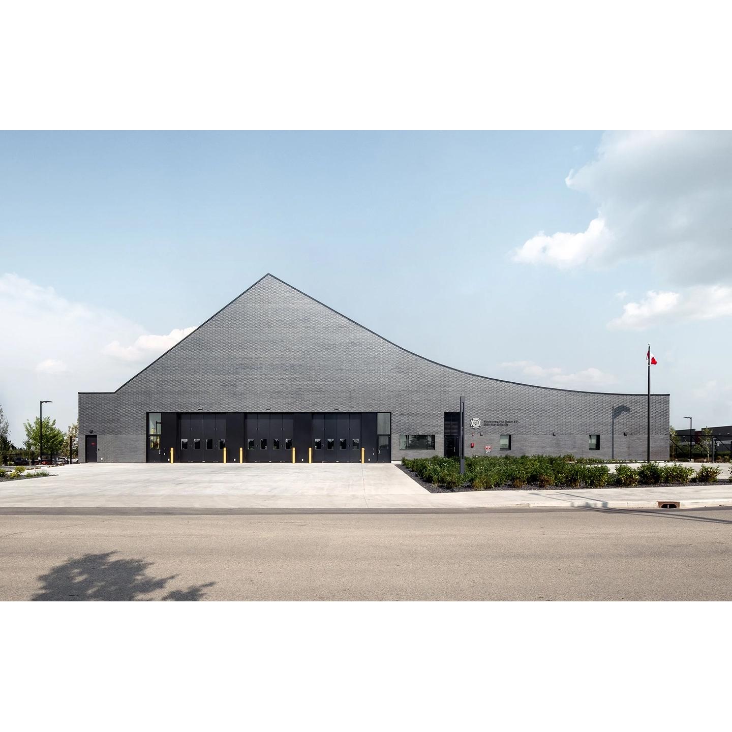 The fire hall brings together a sinuously curved roof and a ring of greenery.