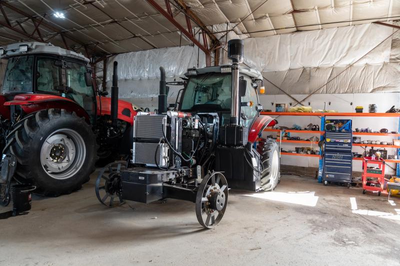 A completed Ursa Ag tractor fitted with a front-end loader and grapple bucket sits outside the company's shop in Bowden, Alta., on Oct. 5, 2026. Ursa Ag builds deliberately low-tech tractors designed so that farmers can repair them themselves. (Photo: Bryce Meyer / Be Giant)