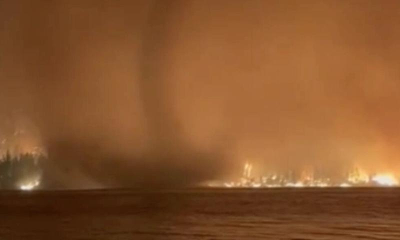 A fire tornado that formed over Gun Lake during the 2023 fires. They're caused by rising superheated air being twisted by shifting winds into a vertical funnel. The climate crisis’ extreme weather is making these fire whirls – once incredibly rare – more common.