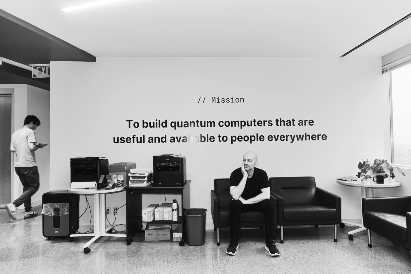 Christian Weedbrook sits on a couch in the Xanadu office in Toronto, black and white photo