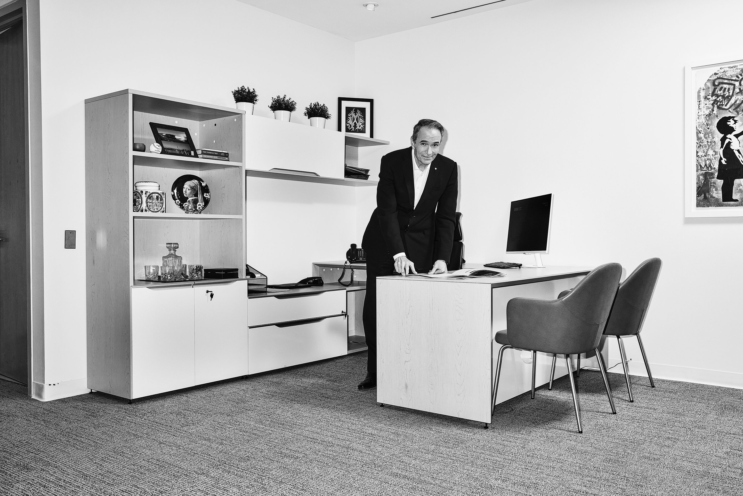 Kevin Smith, the president and CEO at Universal Health Network, stands behind a desk in an office