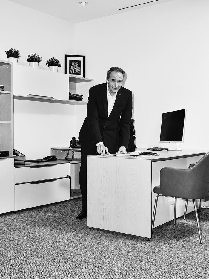 Kevin Smith, the president and CEO at Universal Health Network, stands behind a desk in an office