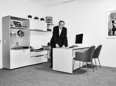 Kevin Smith, the president and CEO at Universal Health Network, stands behind a desk in an office