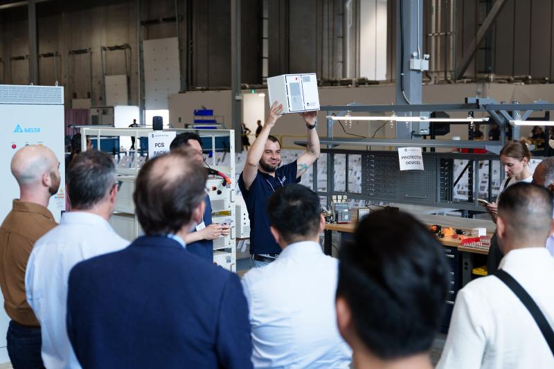 A Moment Energy employee holding a rectangular device at a facility
