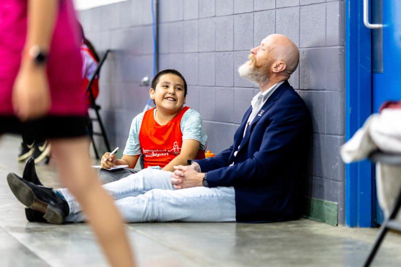 Tim Adams on the sidelines with one of the kids in Edmonton's Free to Play elementary school program. A chance moment at a school led him to start what was then called Free Footie.