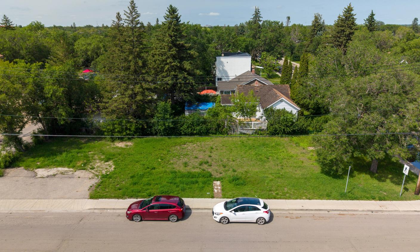An empty, overgrown lot sits next to a boarded up home in Regina, S.K.