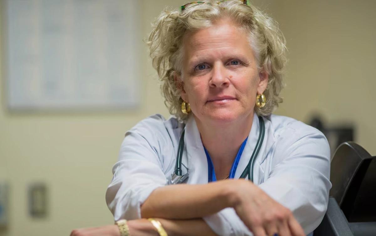 A portrait of cardiologist Dr. Heather Ross, shown from the chest up wearing a stethoscope and looking at the camera with her arms crossed