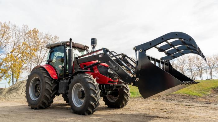A completed Ursa Ag tractor fitted with a front-end loader and grapple bucket sits outside the company's shop in Bowden, Alta., on Oct. 5, 2026. Ursa Ag builds deliberately low-tech tractors designed so that farmers can repair them themselves. (Photo: Bryce Meyer / Be Giant)