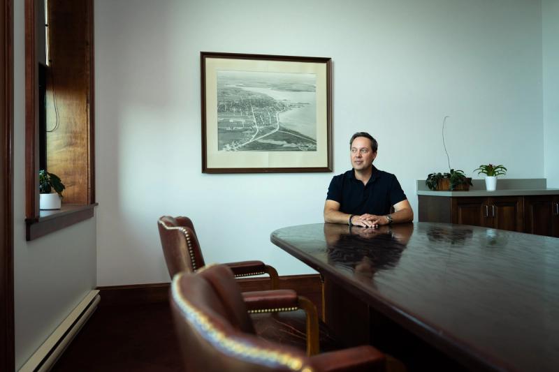 Dan Kutcher in front of a 1950s photograph of Summerside in the City Hall boardroom.