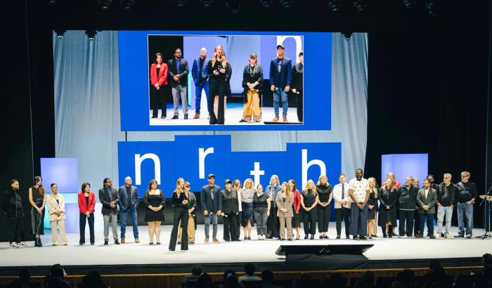 A group of people on stage with the word nrth in the background