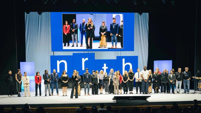 A group of people on stage with the word nrth in the background