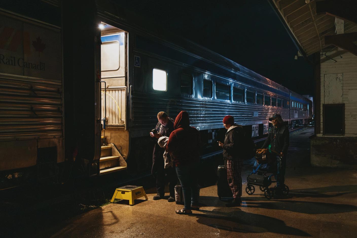 Passengers have their tickets checked before boarding the train in Gillam, Manitoba in the early morning of September 27, 2026.