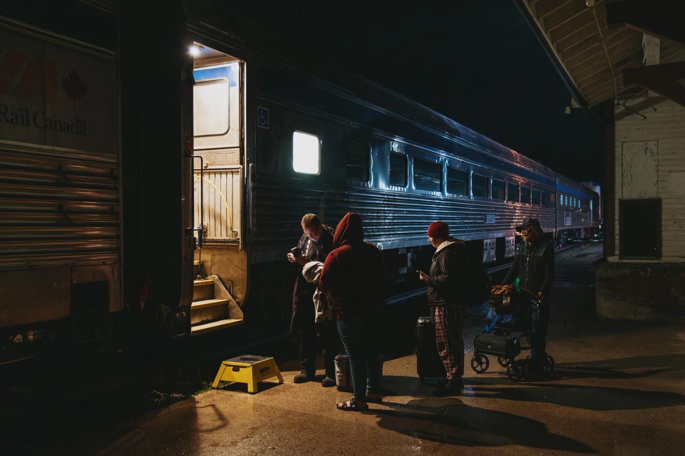 Passengers have their tickets checked before boarding the train in Gillam, Manitoba in the early morning of September 27, 2026.