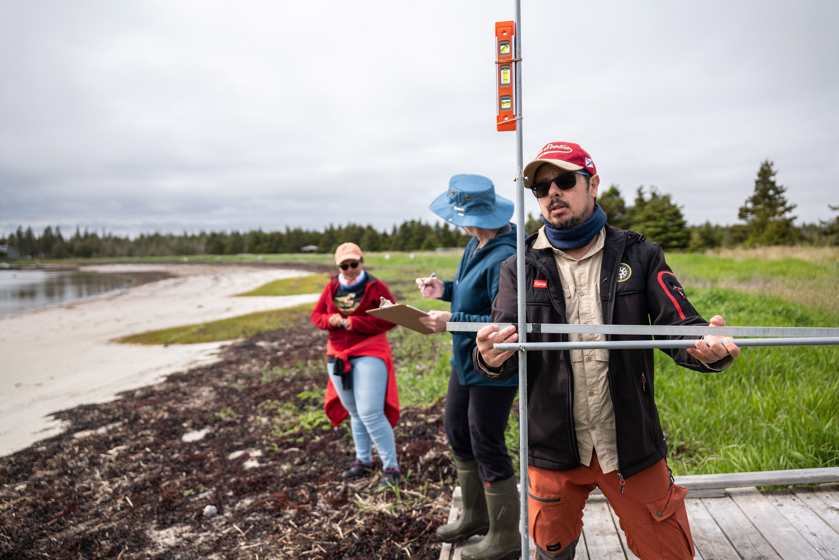 Coastal geographer Camilo Botero measures erosion levels with a device made from four dollar-store curtain rods in Black Duck Cove Provincial Park in Little Dover, N.S., on June 14, 2026.