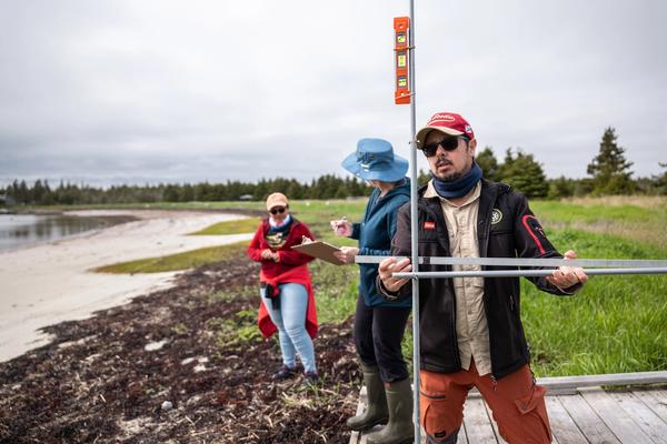 Coastal geographer Camilo Botero measures erosion levels with a device made from four dollar-store curtain rods in Black Duck Cove Provincial Park in Little Dover, N.S., on June 14, 2026.